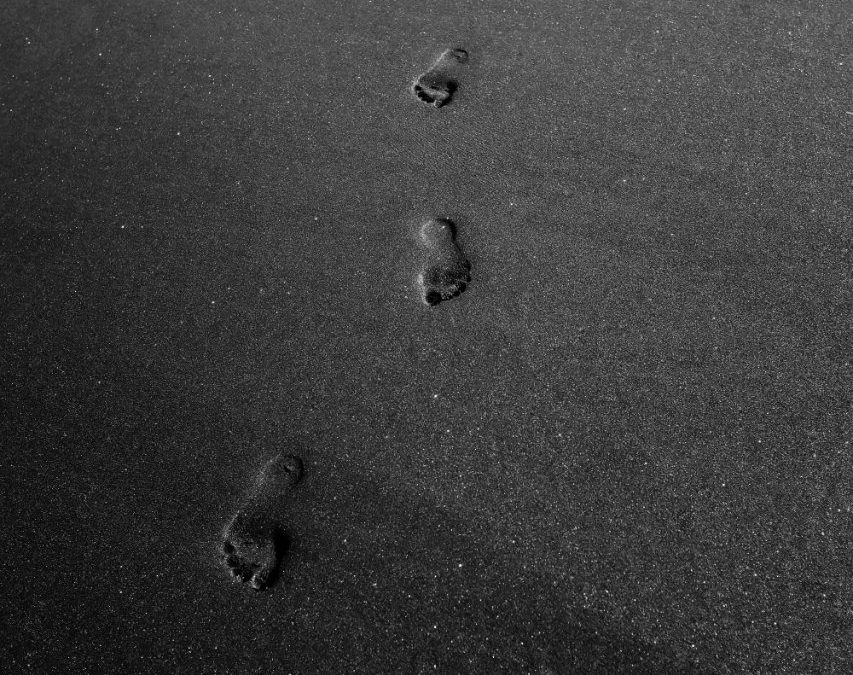 foot prints on gray sand
