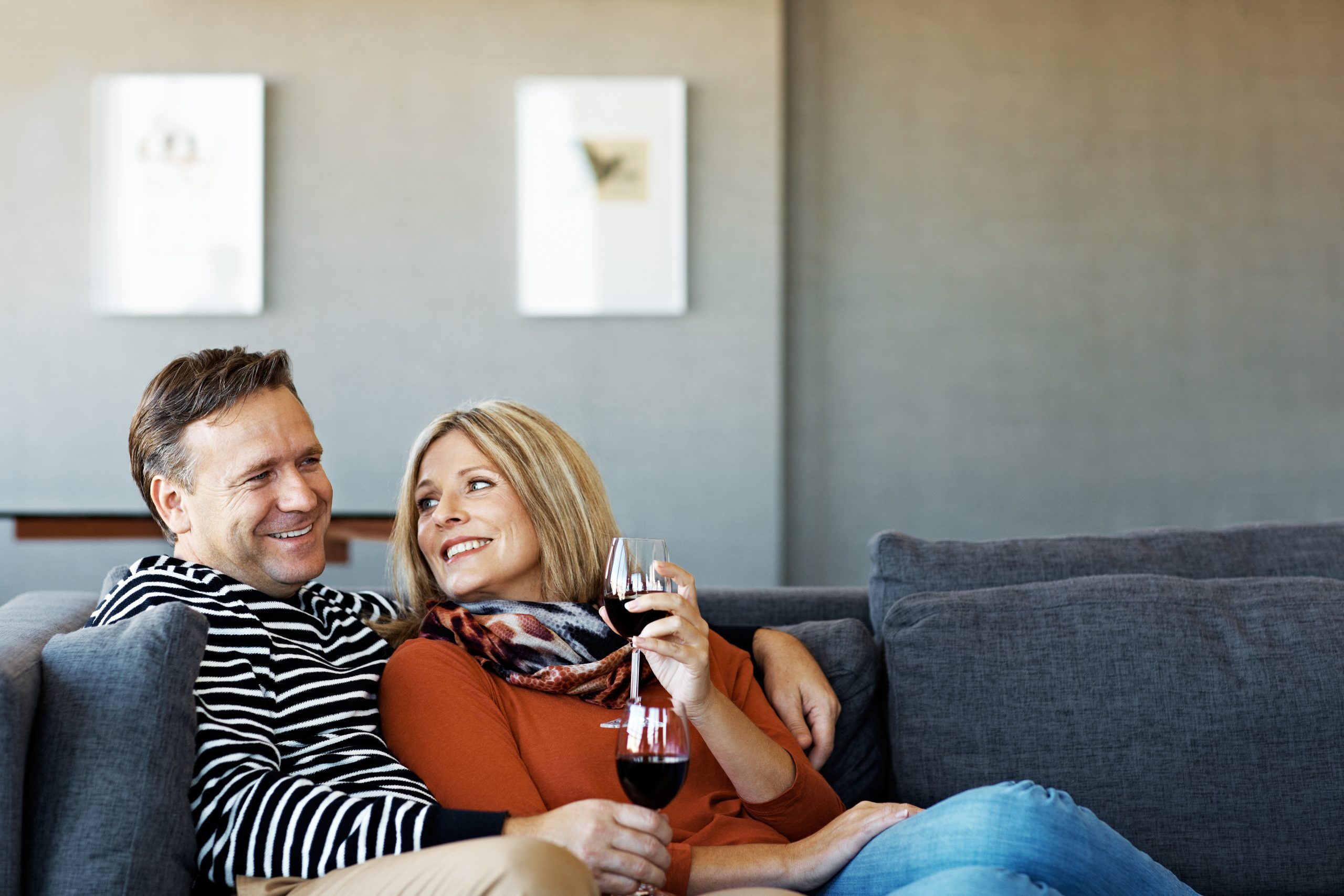 Shot of a smiling mature couple sitting on their sofa drinking wine